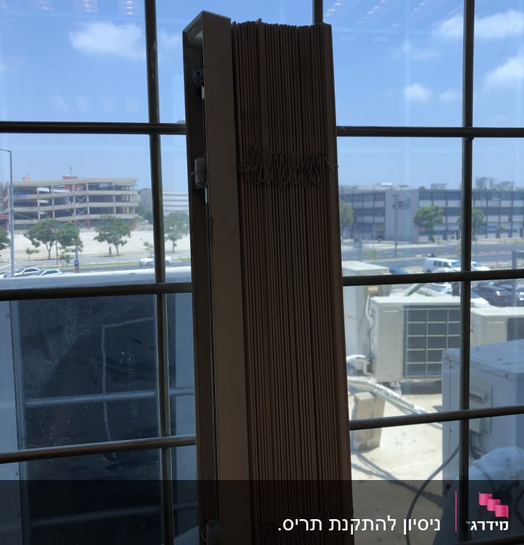 תריסים אנכיים ליד חלון עם נוף חיצוני